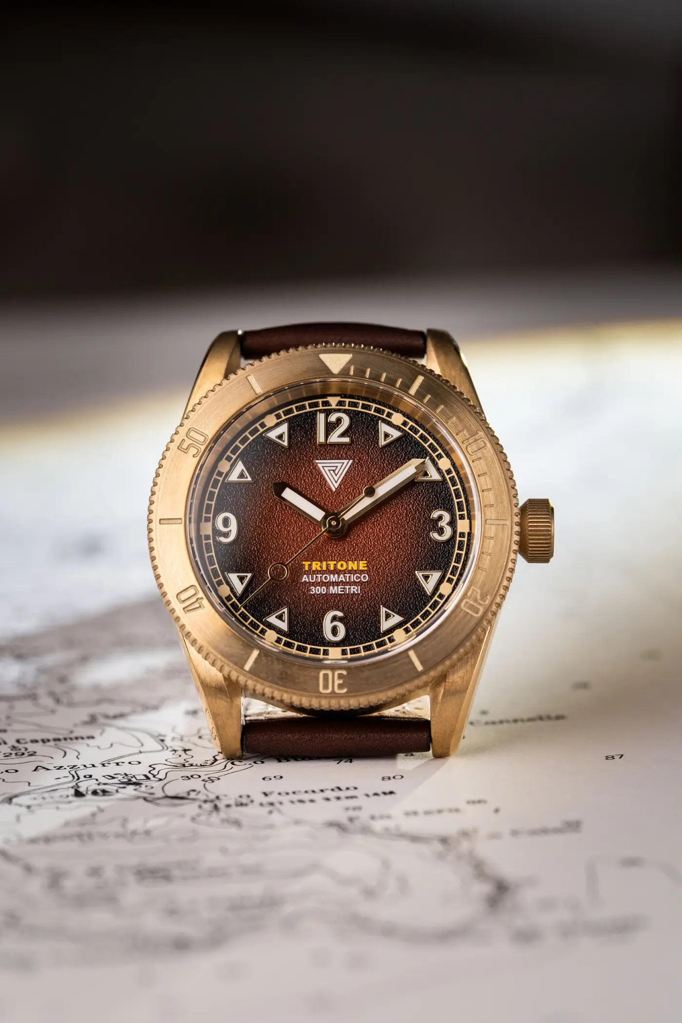Orologio Vertigo Tritone bronzo con quadrante roccia rossa vista frontale su sfondo mappa